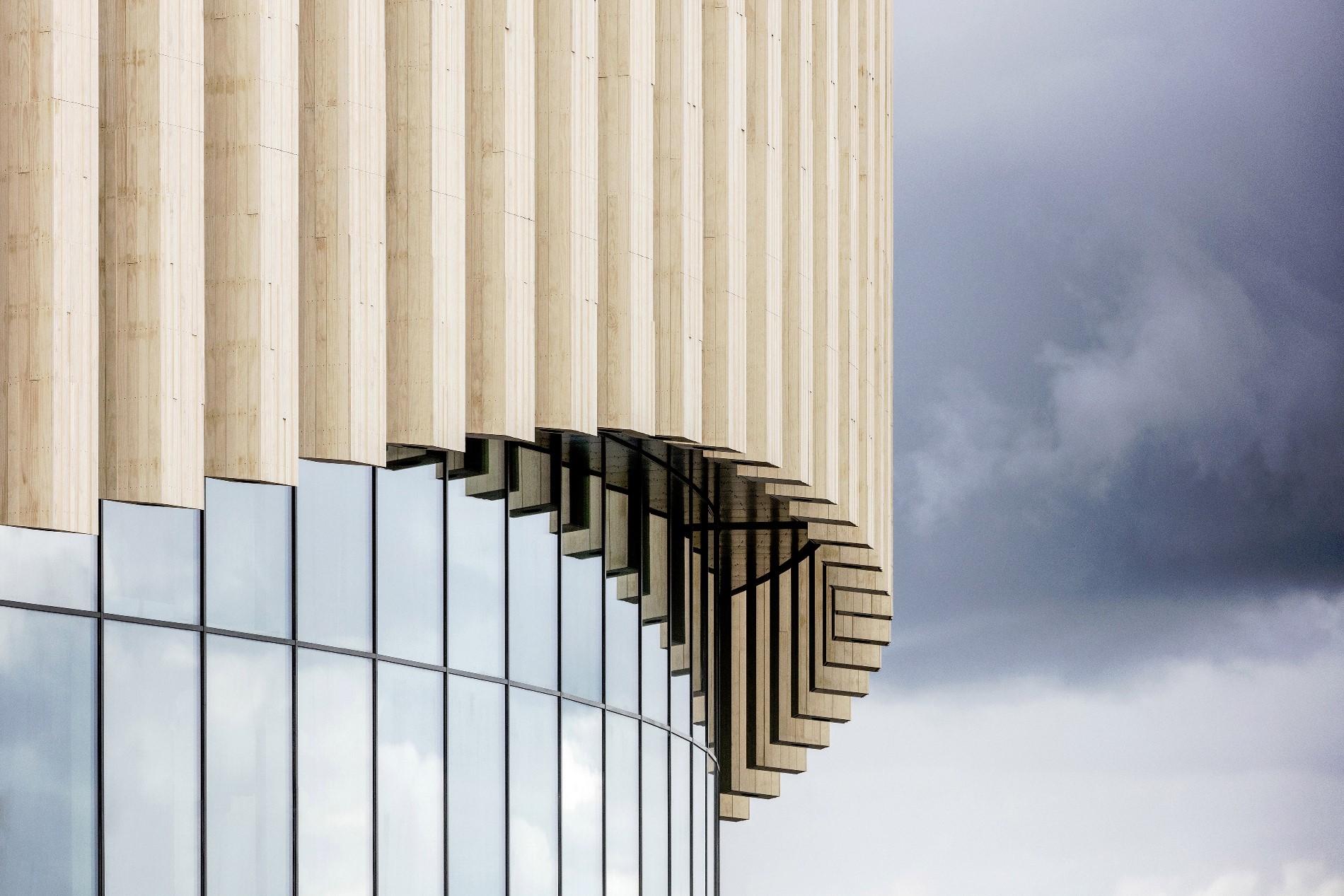 La facciata ondulata semitrasparente sembra danzare sopra il podio circostante sollevandosi leggermente in corrispondenza degli ingressi © Adam Mørk